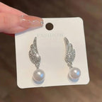 Angel Wings Earrings with pearl Material:- Alloy Copper+ Stones + Silver plating Colour:- Silver