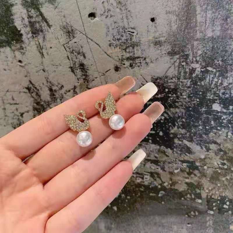 Swan stud earrings for womenMaterial:- Alloy zinc, pearl and zirconColor :- Gold