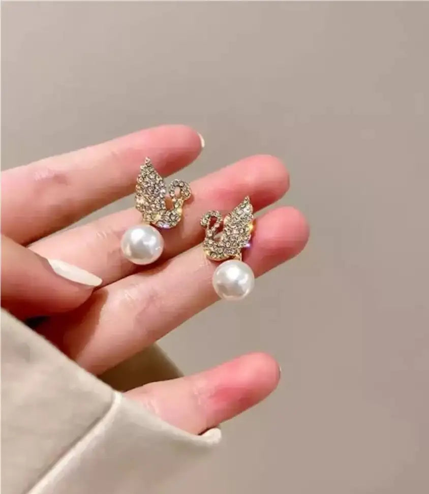 Swan stud earrings for womenMaterial:- Alloy zinc, pearl and zirconColor :- Gold